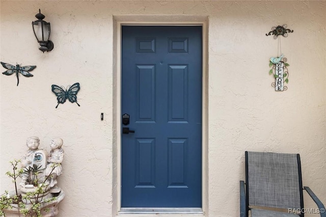 view of exterior entry with stucco siding