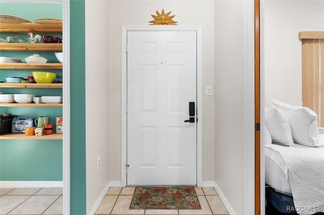 entryway with light tile patterned floors and baseboards