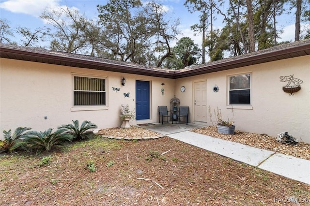 view of exterior entry with stucco siding