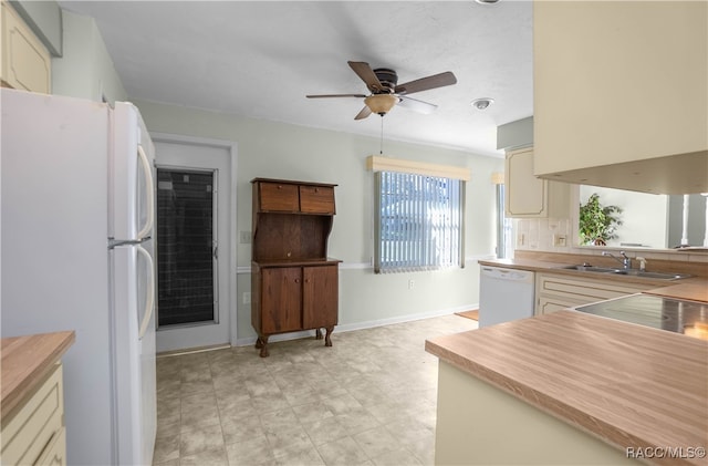 kitchen featuring white appliances, sink, ceiling fan, decorative backsplash, and cream cabinetry