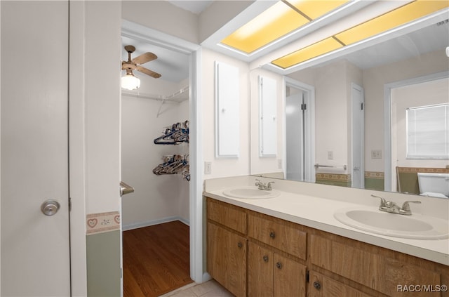 bathroom featuring ceiling fan, hardwood / wood-style floors, and vanity