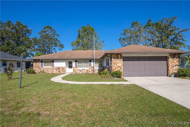 ranch-style home with central air condition unit, a front yard, and a garage