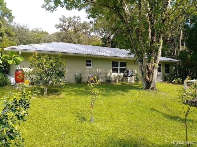 rear view of house featuring a lawn