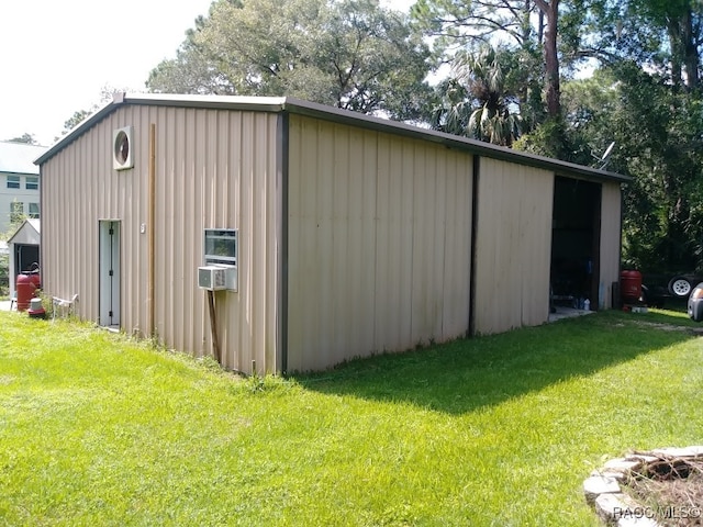 view of outdoor structure featuring cooling unit and a lawn