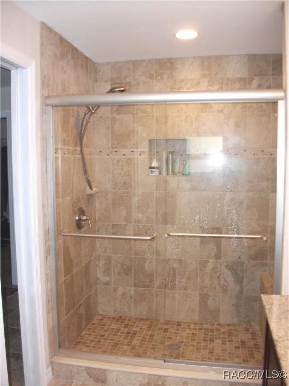 bathroom with vanity and a shower with shower door