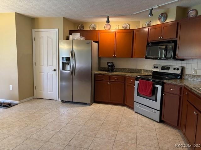 kitchen with track lighting, a textured ceiling, backsplash, dark countertops, and stainless steel appliances