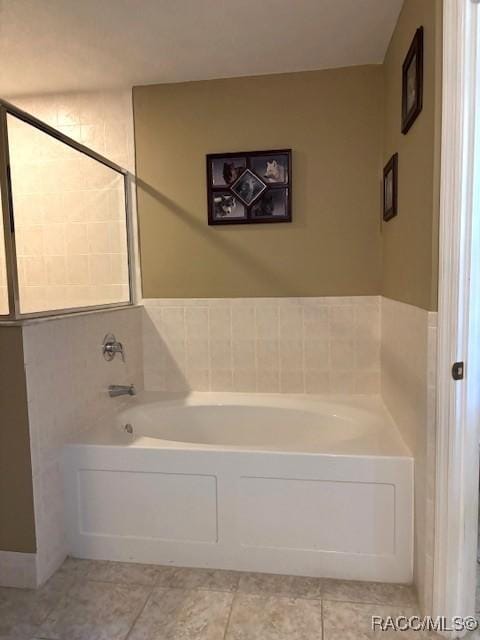 bathroom with tile patterned floors and a garden tub