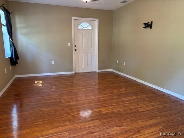 foyer entrance with visible vents, baseboards, and wood finished floors