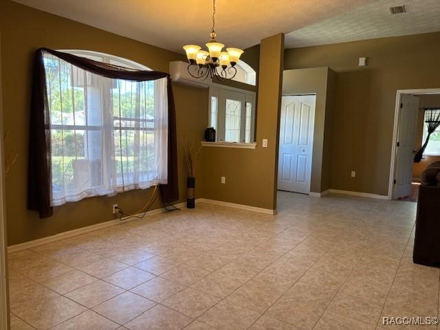 empty room featuring baseboards, light tile patterned floors, a notable chandelier, and visible vents