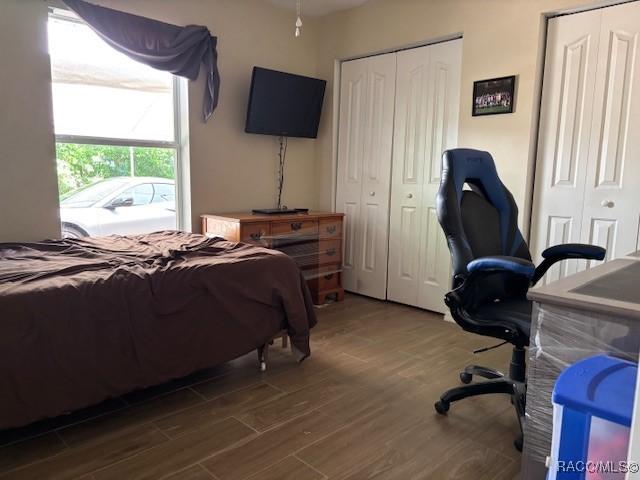 bedroom with two closets and wood finished floors