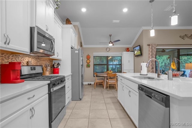 kitchen featuring pendant lighting, sink, appliances with stainless steel finishes, ornamental molding, and white cabinets