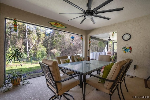 unfurnished sunroom with ceiling fan