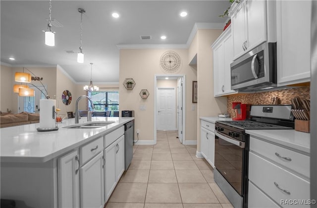 kitchen featuring sink, appliances with stainless steel finishes, a kitchen island with sink, ornamental molding, and white cabinets