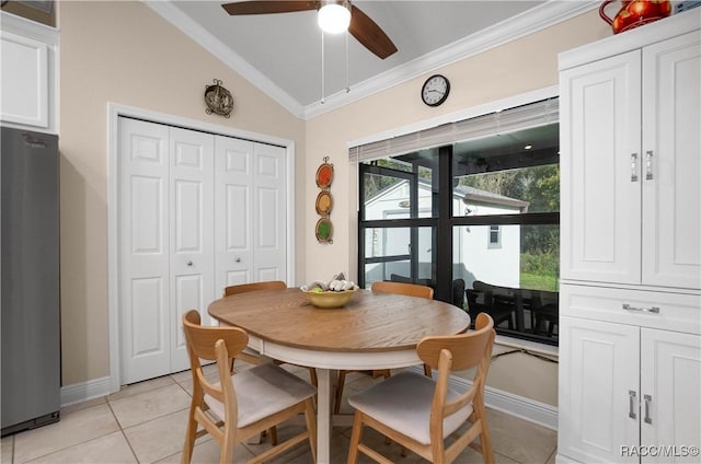 dining room featuring lofted ceiling, light tile patterned floors, ornamental molding, and ceiling fan