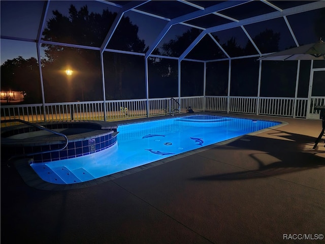 pool at twilight with a lanai, an in ground hot tub, and a patio