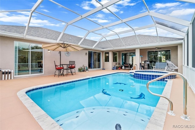 view of swimming pool featuring ceiling fan, a patio area, a lanai, and an in ground hot tub