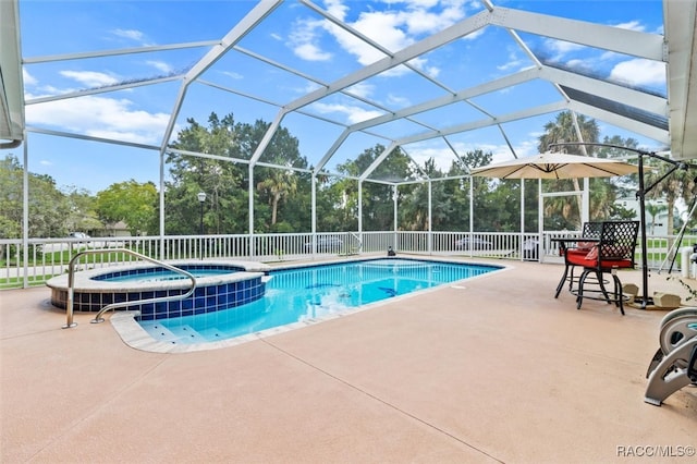 view of pool with glass enclosure, a patio area, and an in ground hot tub