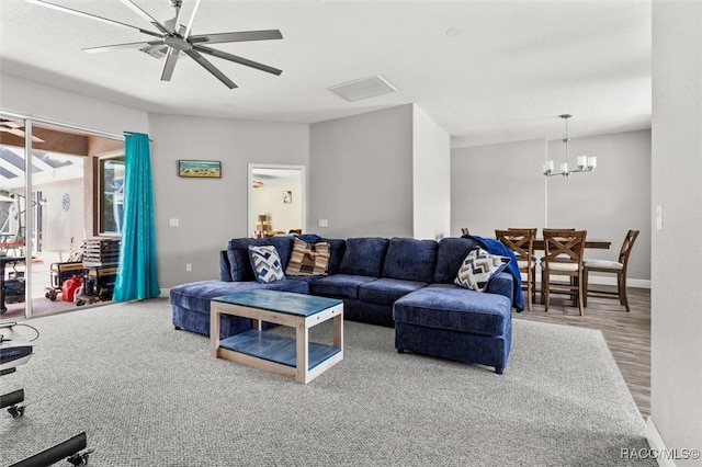 living room featuring wood-type flooring and ceiling fan with notable chandelier