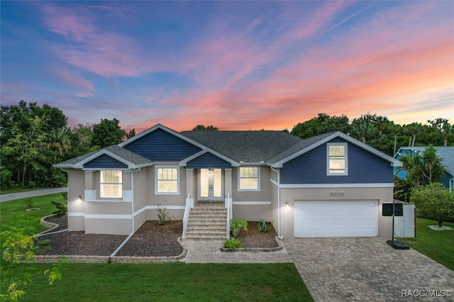 view of front of house featuring a yard, french doors, and a garage