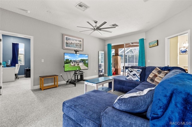 living room with carpet flooring, ceiling fan, and a textured ceiling