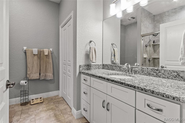 bathroom featuring a shower with door and vanity