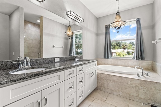 bathroom featuring tile patterned floors, vanity, plus walk in shower, and an inviting chandelier