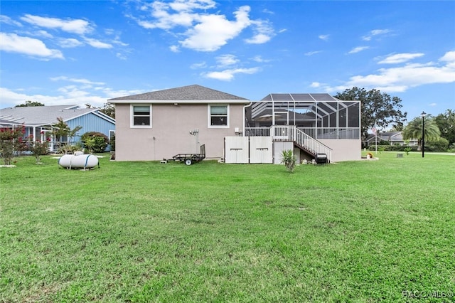 back of house with a lanai and a yard