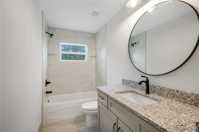 full bathroom with toilet, tiled shower / bath, and vanity