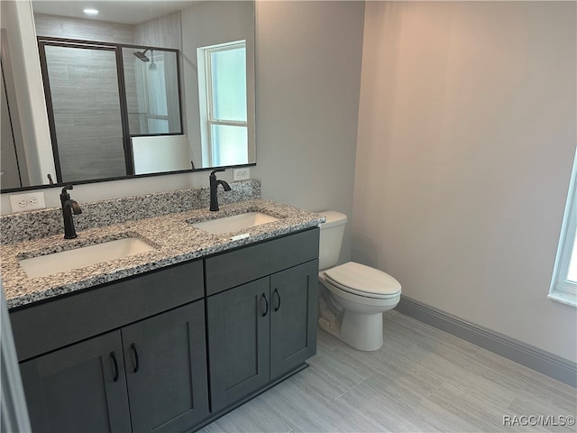 bathroom with toilet, vanity, and an enclosed shower