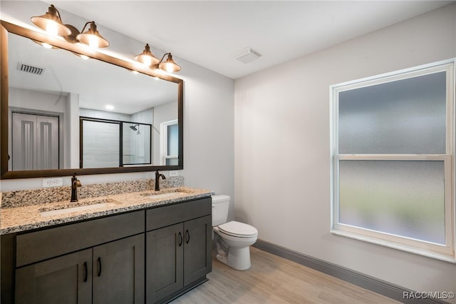 bathroom with an enclosed shower, vanity, wood-type flooring, and toilet