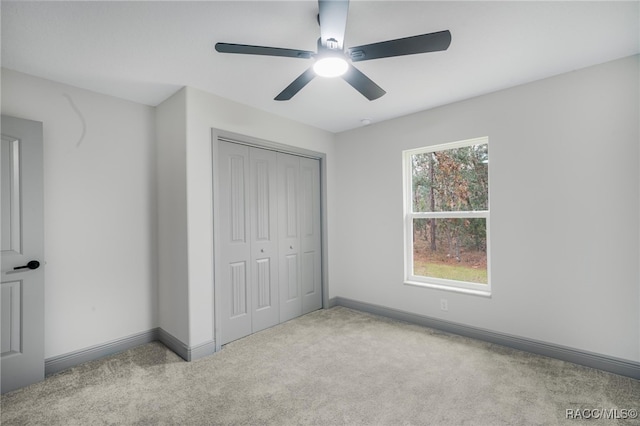 unfurnished bedroom with light carpet, ceiling fan, and a closet