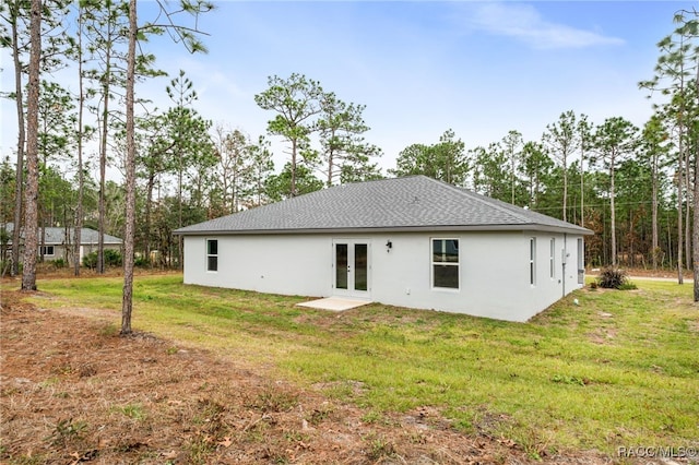 rear view of property with french doors and a yard