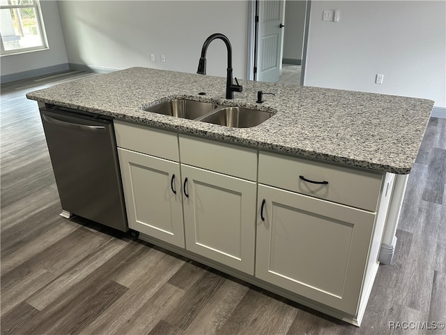 kitchen featuring light stone counters, sink, stainless steel dishwasher, and dark wood-type flooring