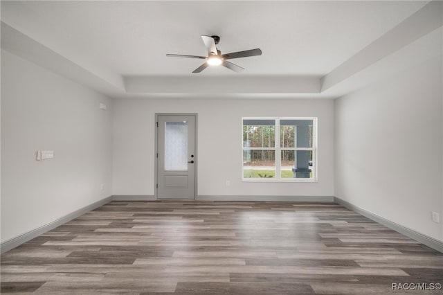 spare room featuring ceiling fan, hardwood / wood-style floors, and a raised ceiling