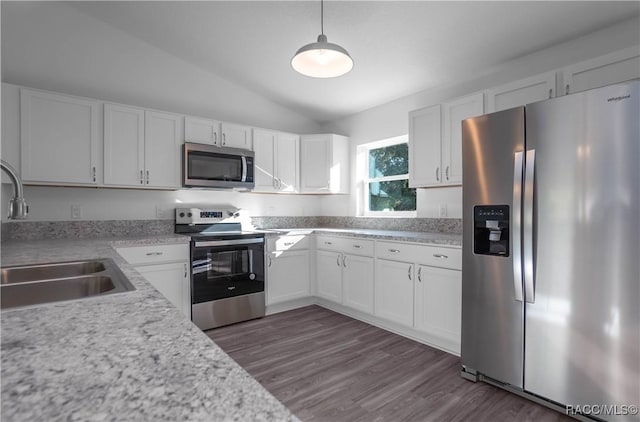 kitchen featuring sink, white cabinetry, vaulted ceiling, hanging light fixtures, and appliances with stainless steel finishes