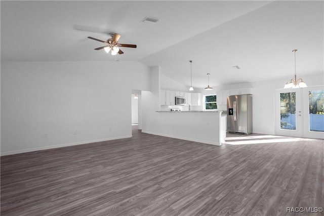 unfurnished living room featuring dark hardwood / wood-style floors, ceiling fan with notable chandelier, high vaulted ceiling, and french doors