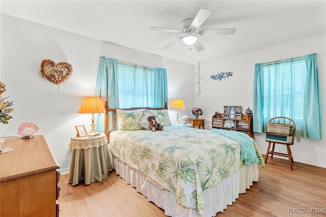 bedroom featuring hardwood / wood-style floors, a textured ceiling, and ceiling fan