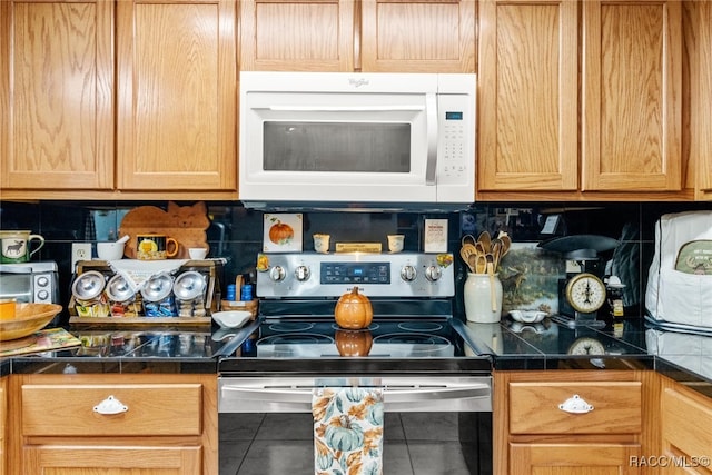 kitchen featuring tile patterned floors, decorative backsplash, and electric stove