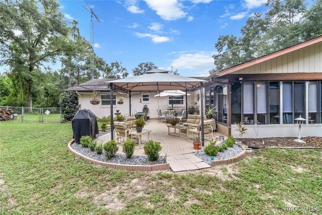 rear view of property with a lawn, a patio area, and a sunroom