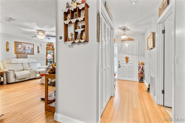 hall featuring hardwood / wood-style flooring and a textured ceiling