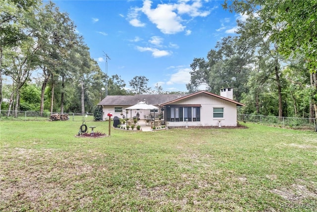 rear view of property with a gazebo and a lawn