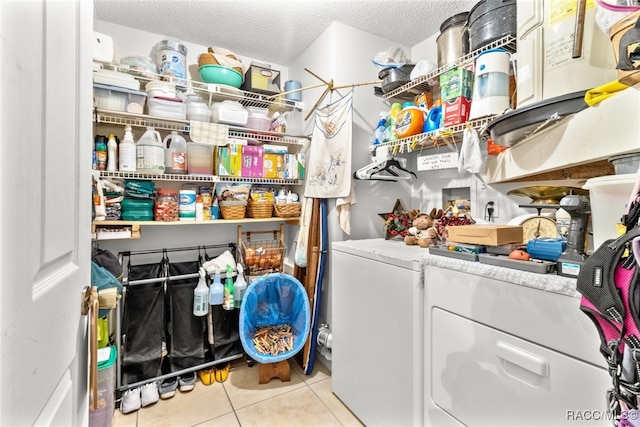 laundry area with light tile patterned floors, a textured ceiling, and separate washer and dryer