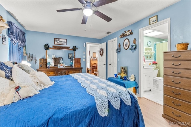 bedroom featuring connected bathroom, ceiling fan, and light hardwood / wood-style flooring