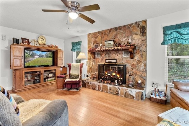 living room with ceiling fan, a fireplace, and hardwood / wood-style flooring