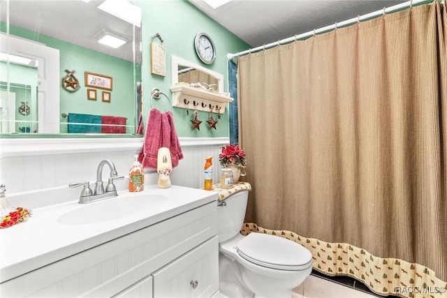 bathroom featuring a skylight, curtained shower, vanity, and toilet