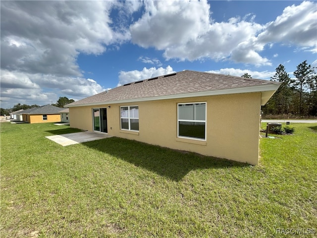 back of property with a patio area and a lawn