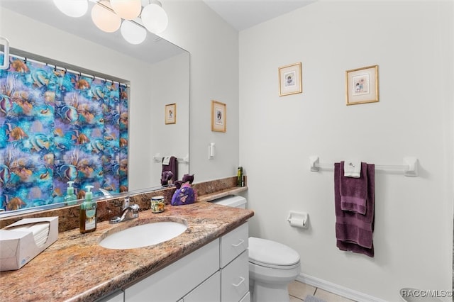 bathroom with tile patterned flooring, vanity, and toilet