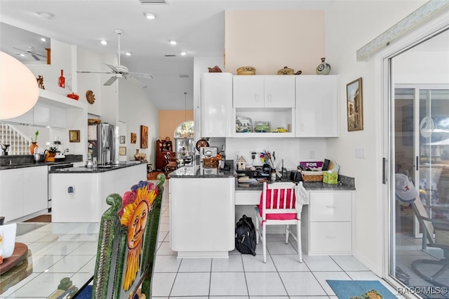 kitchen with white cabinetry, a center island, light tile patterned flooring, and ceiling fan