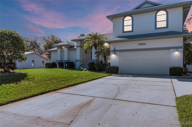 view of front property featuring a garage and a yard