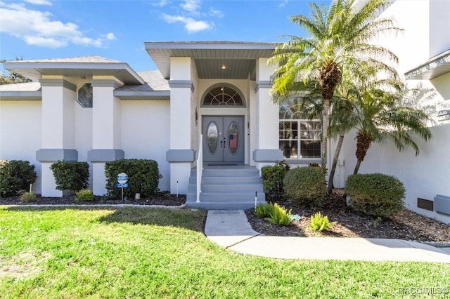 entrance to property with a lawn